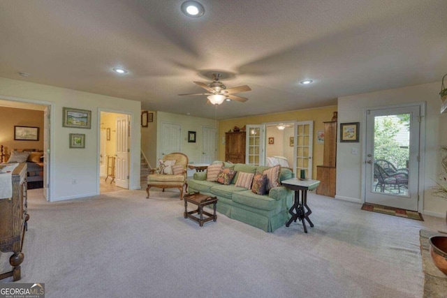 carpeted living room with a textured ceiling and ceiling fan