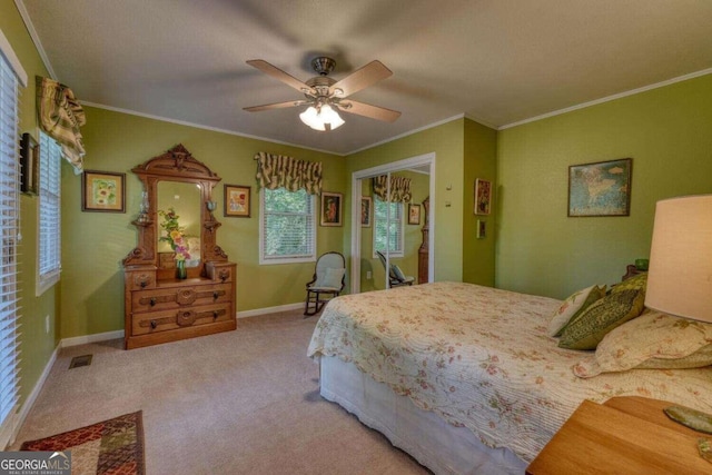 bedroom with a closet, light carpet, ornamental molding, and ceiling fan