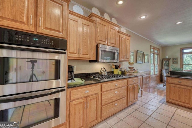 kitchen featuring ornamental molding, light tile patterned flooring, and stainless steel appliances