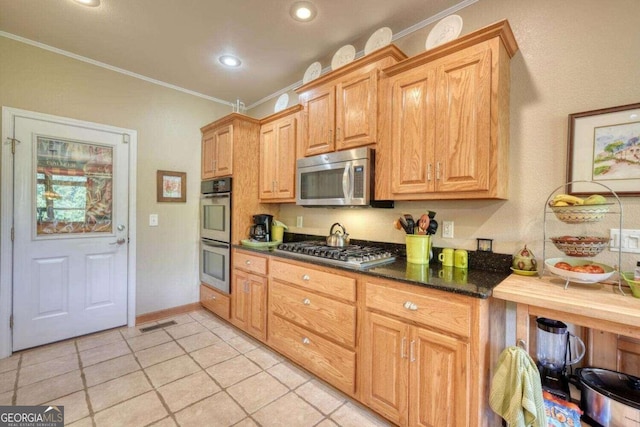 kitchen featuring stainless steel appliances, crown molding, and light tile patterned floors