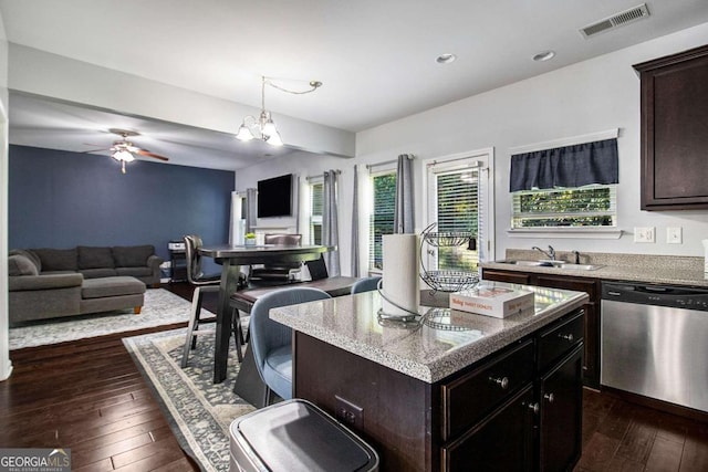 kitchen featuring a center island, a healthy amount of sunlight, stainless steel dishwasher, and dark hardwood / wood-style floors