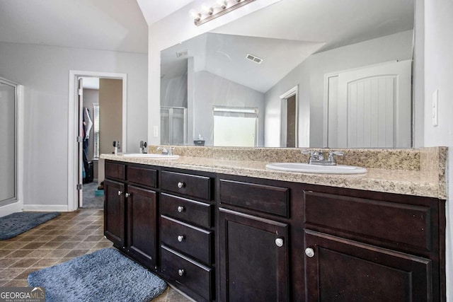 bathroom featuring lofted ceiling, a shower with shower door, and vanity