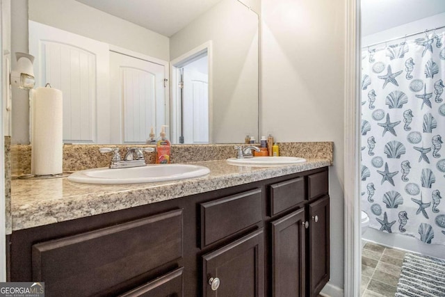 bathroom with curtained shower, vanity, and toilet