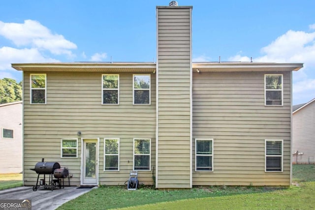 rear view of house featuring a yard and a patio area