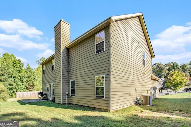 back of house with cooling unit and a yard