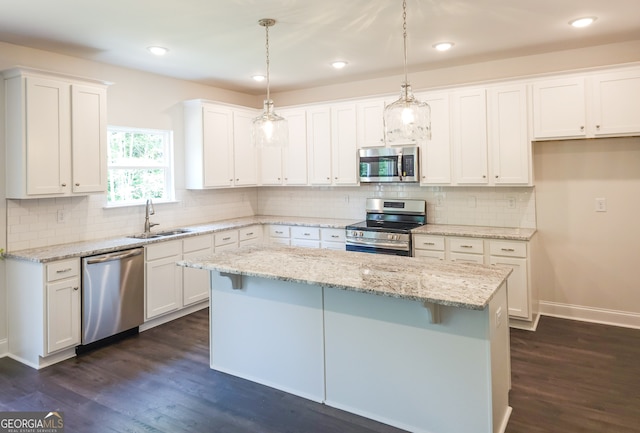 kitchen with sink, white cabinets, decorative light fixtures, and appliances with stainless steel finishes