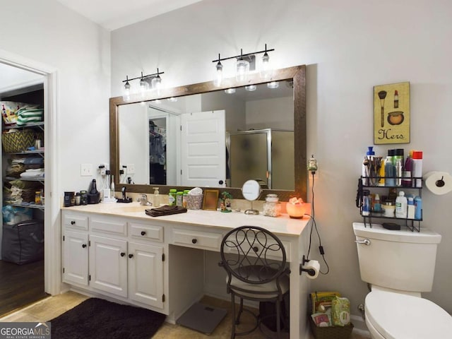 bathroom featuring toilet, walk in shower, wood-type flooring, and vanity