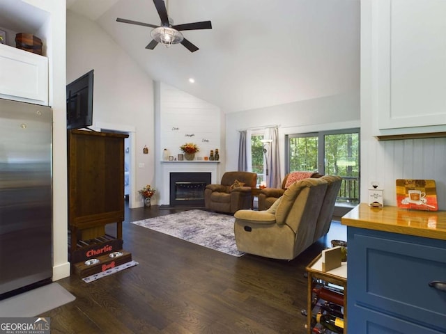 living room featuring dark hardwood / wood-style floors, high vaulted ceiling, and ceiling fan