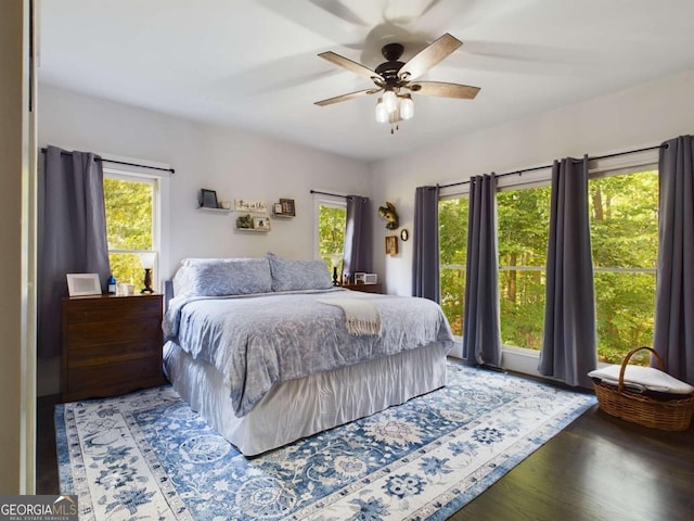 bedroom featuring wood-type flooring, multiple windows, and ceiling fan