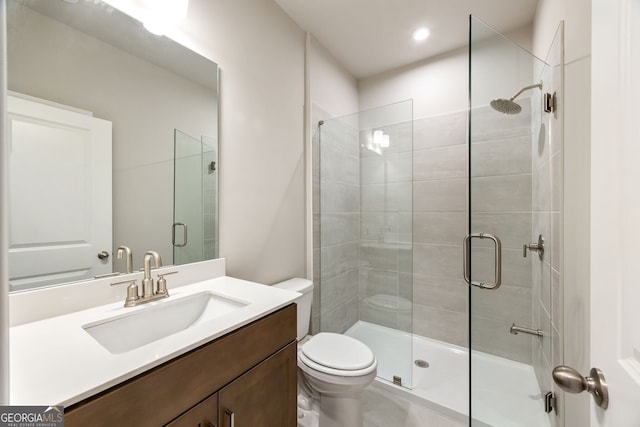 bathroom featuring vanity, toilet, and an enclosed shower