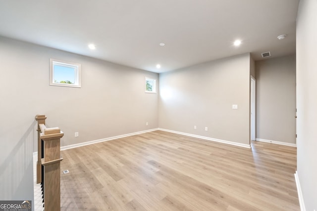 basement with light hardwood / wood-style floors and a wealth of natural light