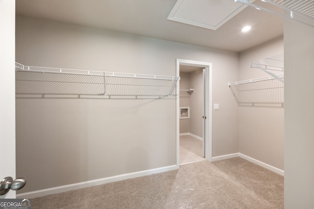 walk in closet featuring light carpet