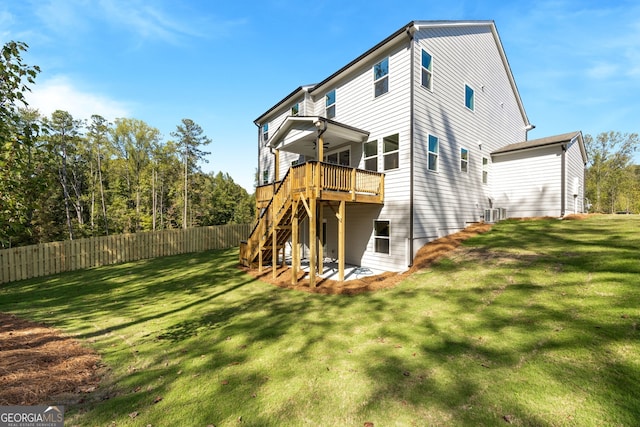 back of property featuring a deck and a lawn