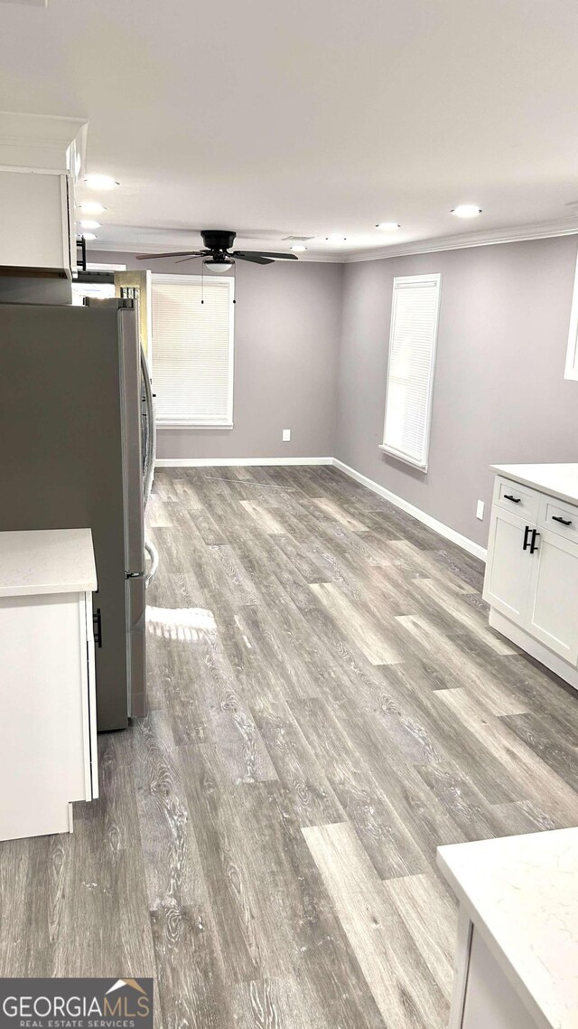 interior space featuring ornamental molding, hardwood / wood-style flooring, and stainless steel refrigerator