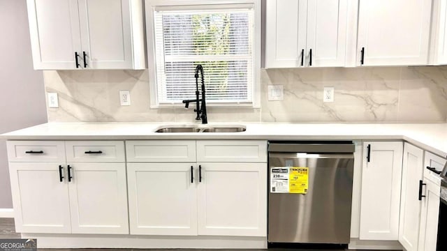 kitchen featuring white cabinets, dishwasher, backsplash, and sink