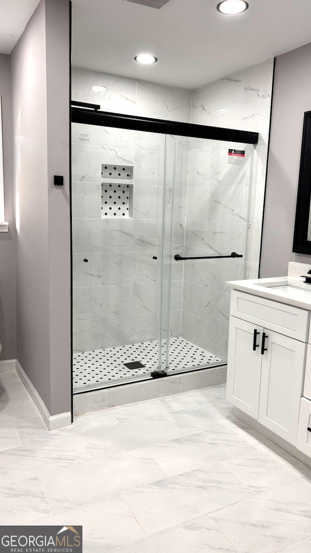 bathroom with vanity and a shower with door