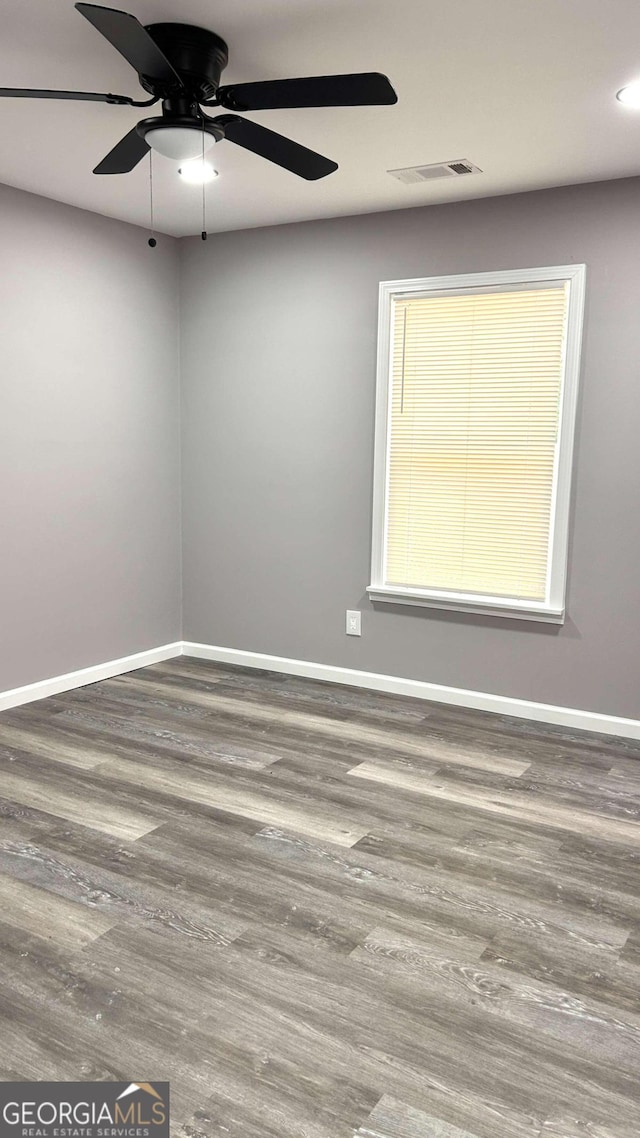 spare room with hardwood / wood-style floors and ceiling fan