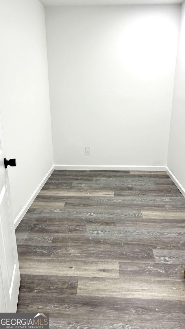 unfurnished room with dark wood-type flooring