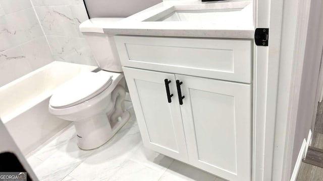 bathroom with vanity, toilet, and a tub