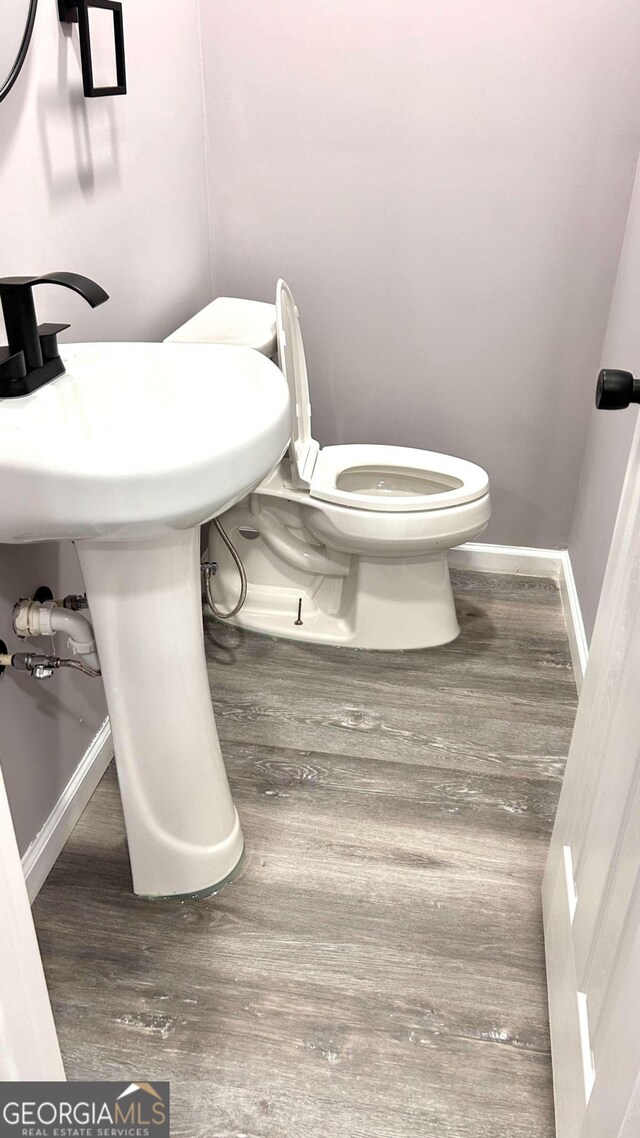 bathroom with sink, toilet, and wood-type flooring