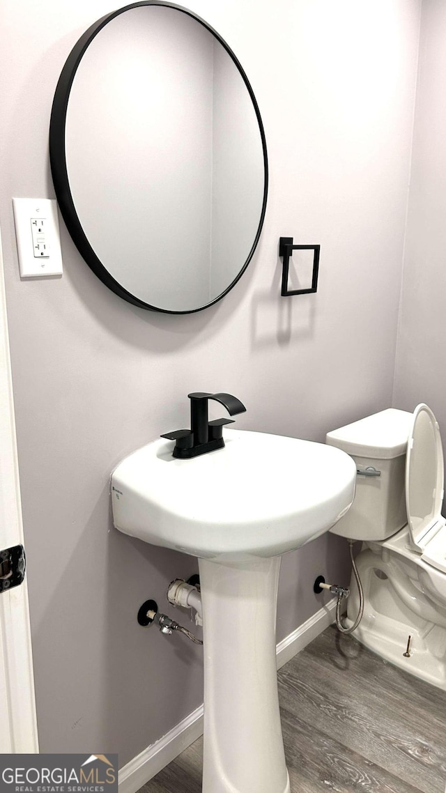 bathroom featuring hardwood / wood-style flooring and toilet