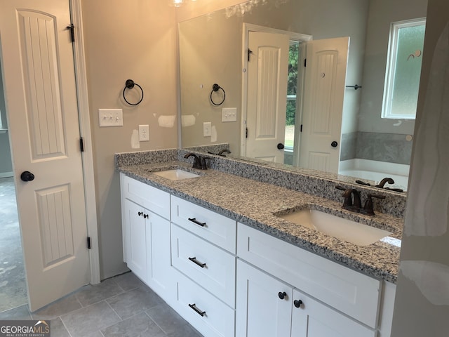 bathroom featuring vanity, a bathing tub, and tile patterned floors