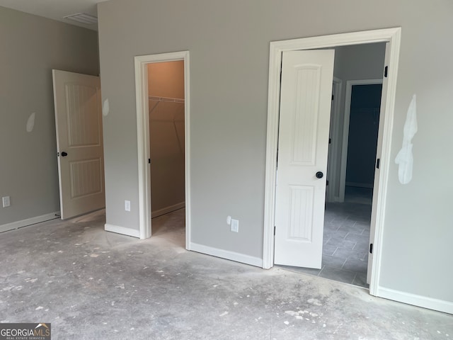 unfurnished bedroom with a closet and a walk in closet