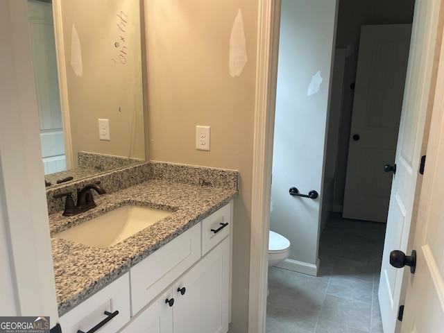 bathroom featuring vanity, toilet, and tile patterned floors