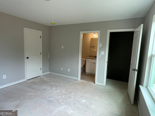 unfurnished bedroom featuring a closet and ensuite bath