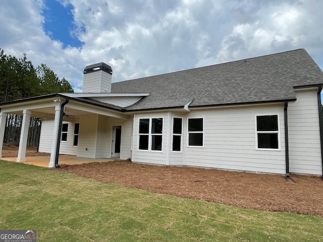 back of house featuring a lawn and a patio