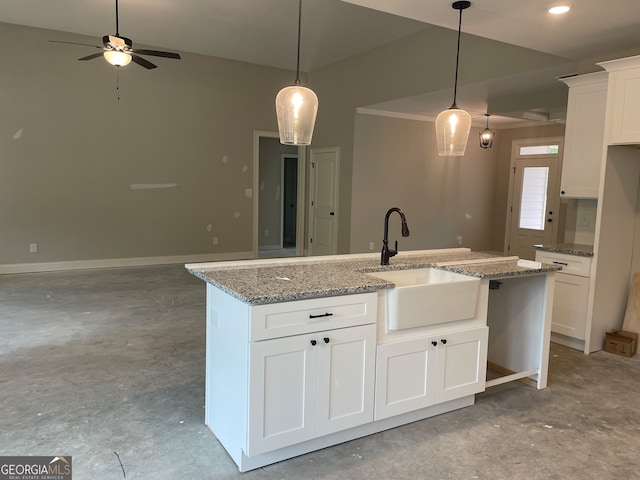 kitchen featuring white cabinets, a center island with sink, and sink