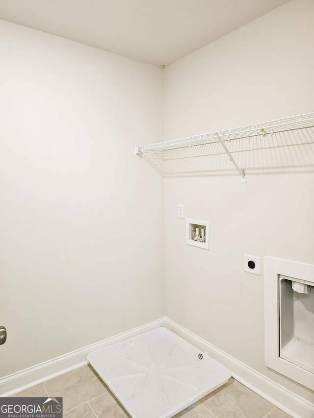 clothes washing area featuring gas dryer hookup, light tile patterned floors, washer hookup, and hookup for an electric dryer