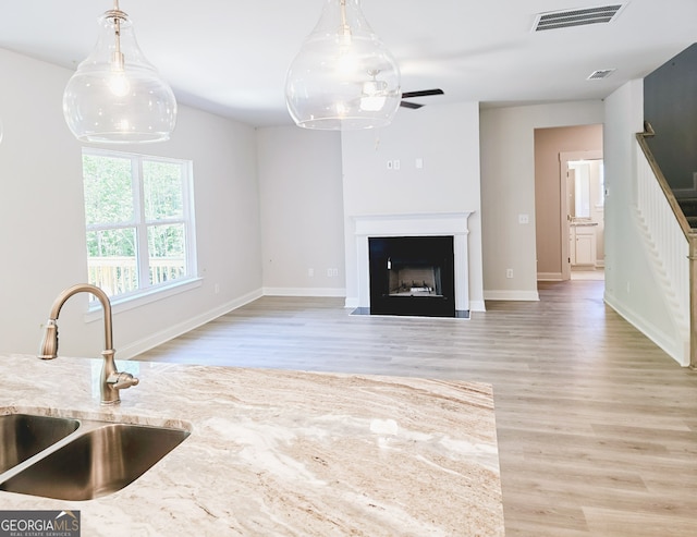 unfurnished living room featuring sink and light hardwood / wood-style flooring