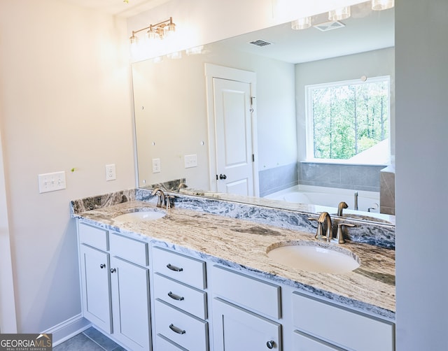 bathroom with tile patterned flooring, vanity, and a bathtub