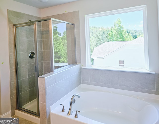 bathroom featuring plenty of natural light and independent shower and bath