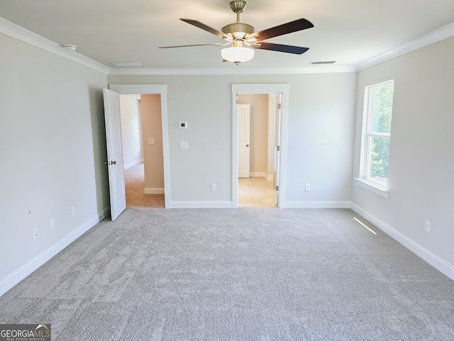 unfurnished bedroom with ceiling fan, light colored carpet, ornamental molding, and ensuite bathroom