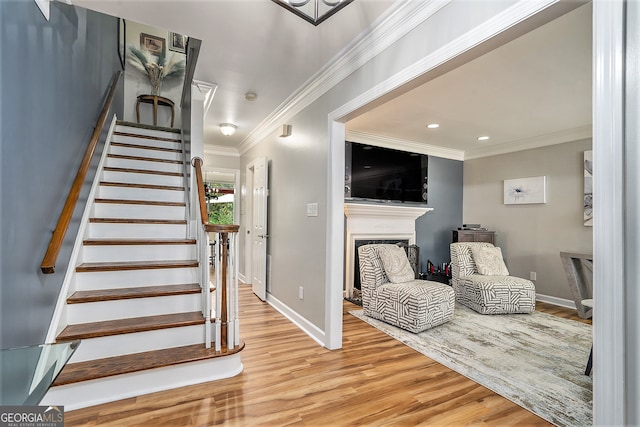 stairway with crown molding and hardwood / wood-style flooring