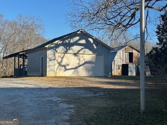 view of side of home featuring an outbuilding and a garage