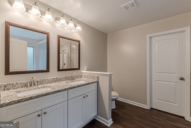 bathroom featuring wood-type flooring, vanity, and toilet