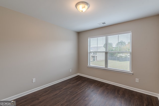 empty room with dark hardwood / wood-style flooring