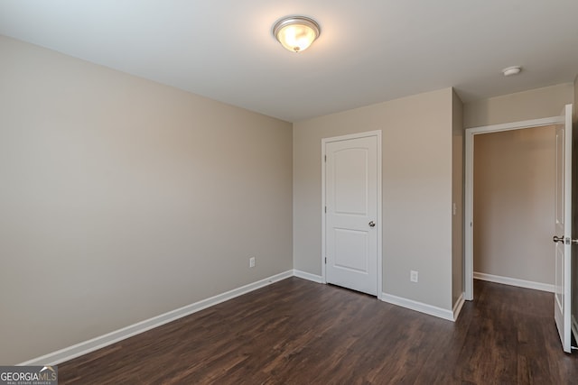 unfurnished bedroom featuring dark hardwood / wood-style floors and a closet