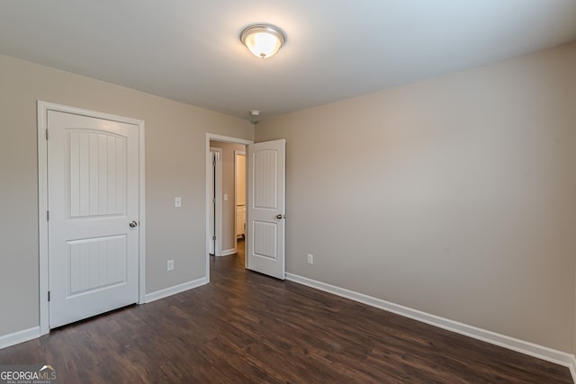 unfurnished bedroom with dark wood-type flooring