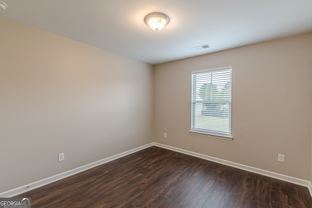 spare room featuring dark wood-type flooring