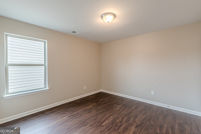 spare room with dark wood-type flooring