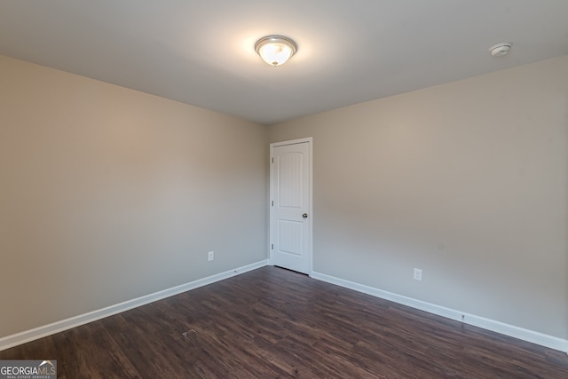 unfurnished room with dark hardwood / wood-style flooring