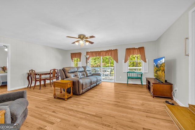 living room with light wood-type flooring and ceiling fan