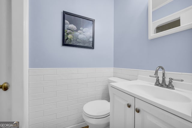 bathroom featuring tile walls, vanity, and toilet