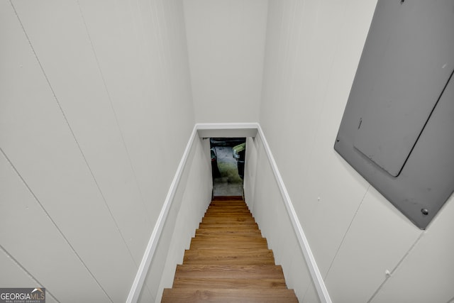 stairway featuring hardwood / wood-style flooring and electric panel