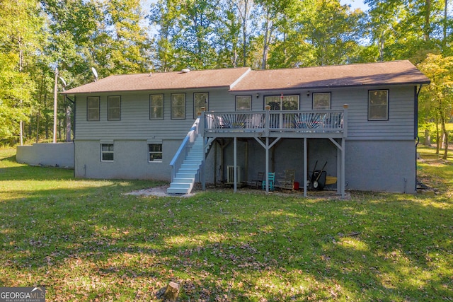 rear view of house with a wooden deck and a lawn