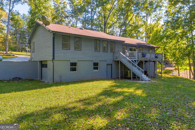 back of property with a deck and a yard